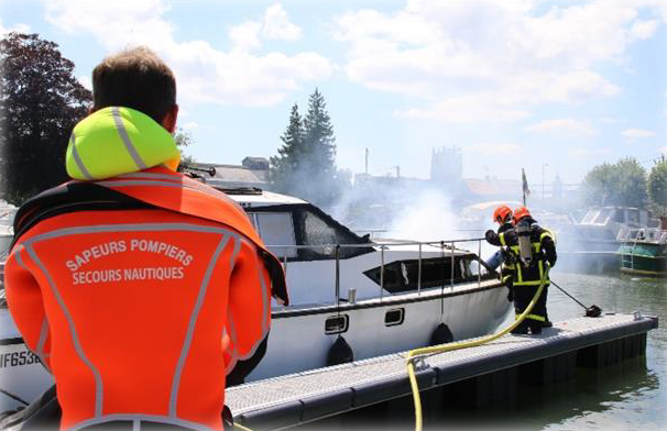des pompiers en intervention sur un bateau de plaisance en feu à Aire-sur-la-Lys