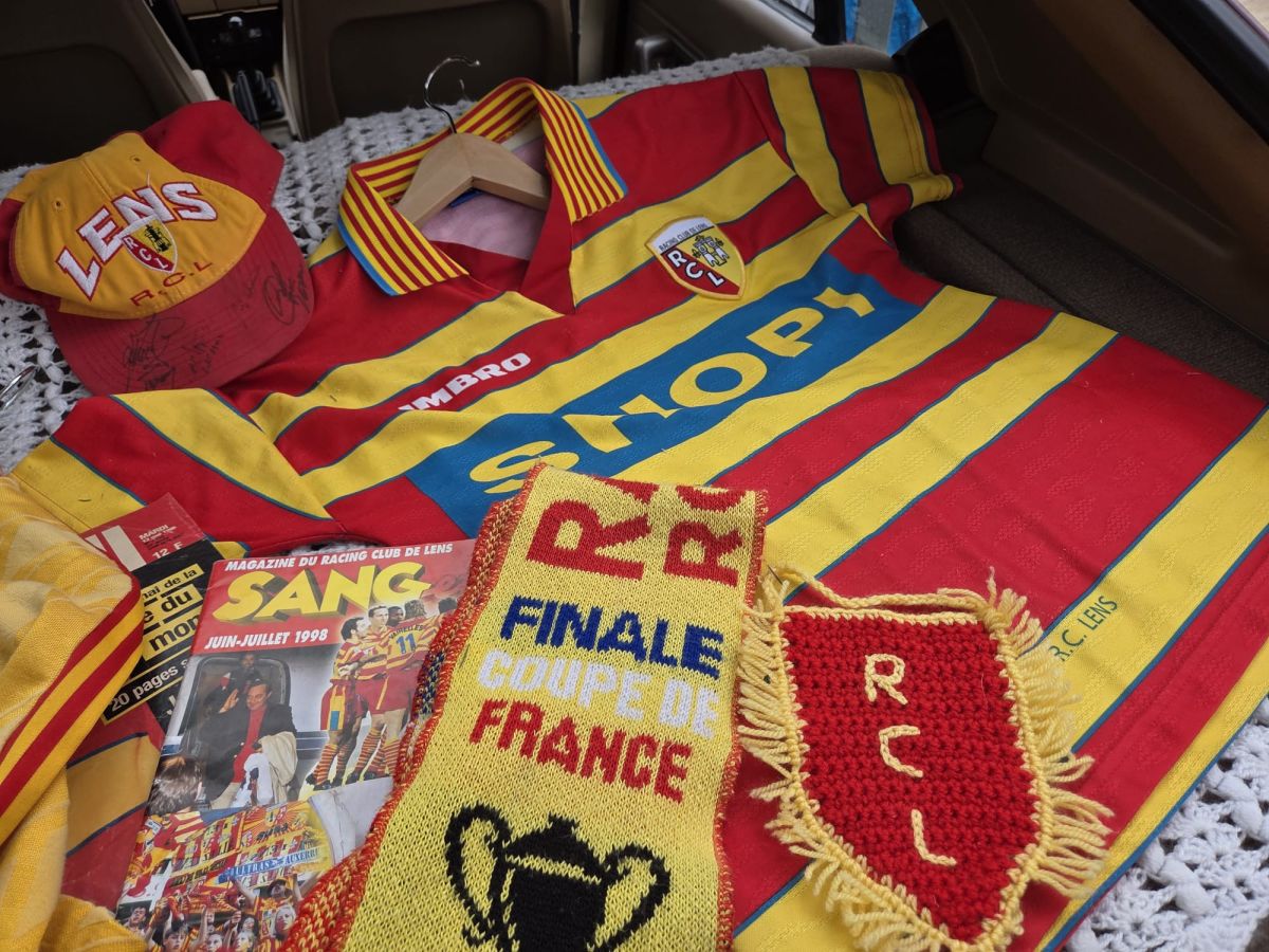 Les supporters du RC Lens se préparent, avec écharpes et maillots aux couleurs du club.