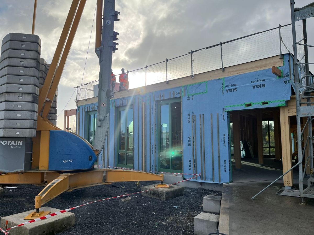 La grue continue de s'affairer sans discontinuer sur le site, en face : la salle de réunion et de co-working.